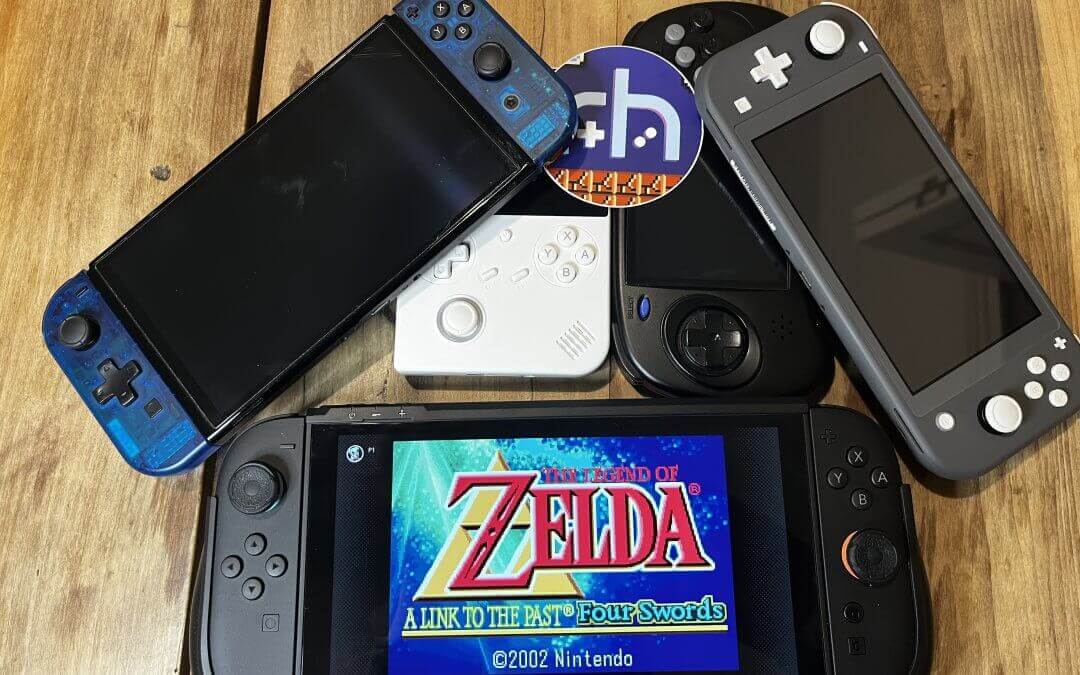 A Switch 2 running Zelda in a pile of other handhelds