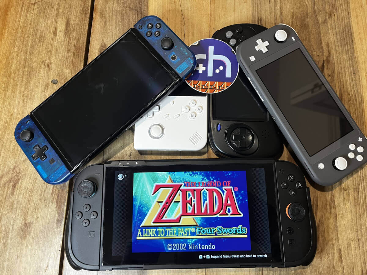 A Switch 2 running Zelda in a pile of other handhelds