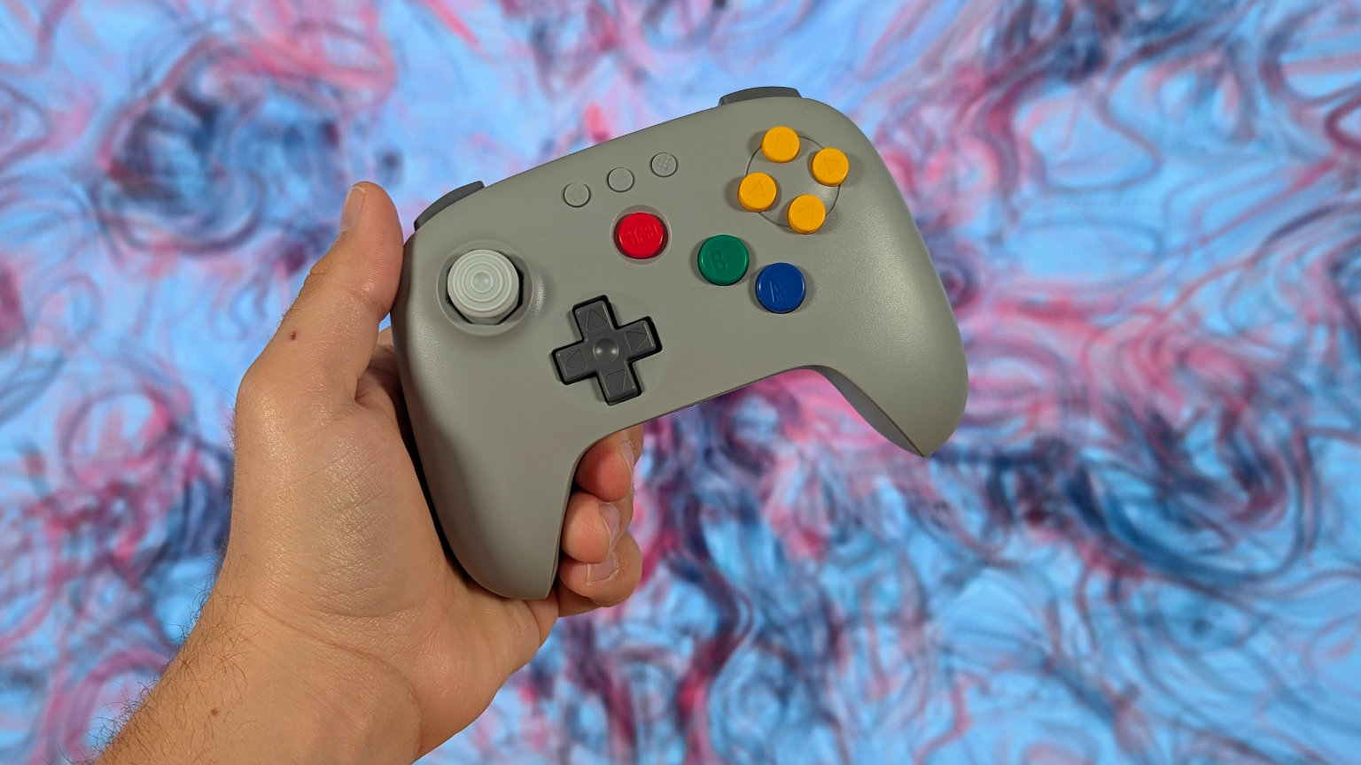 8BitDo 64 In Hand with TV Background